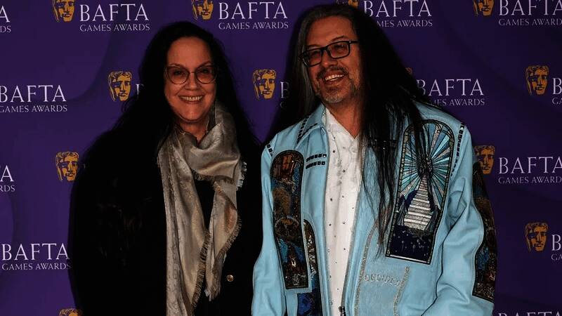 Romero Games创始人约翰·罗梅洛在工作室内与团队成员讨论项目的现场照片