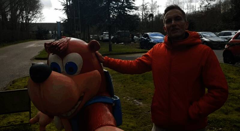 格雷格·梅尔斯工作照，身后是Rare经典游戏墙