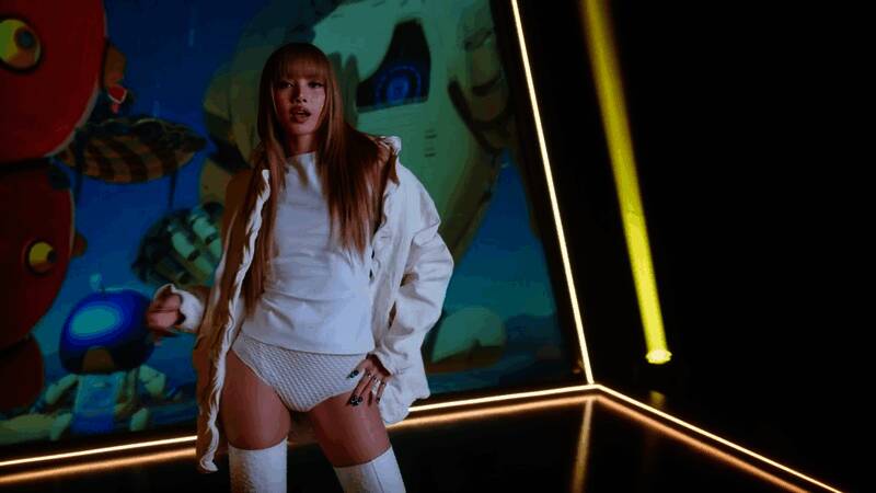 Lisa手持DualSense手柄的特写画面，背景为动态光效渲染的游戏场景