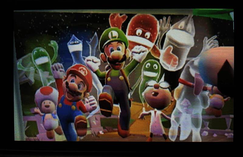 游戏宣传图中路易吉手持手电筒站在门口，背景是神秘阴森的洋馆