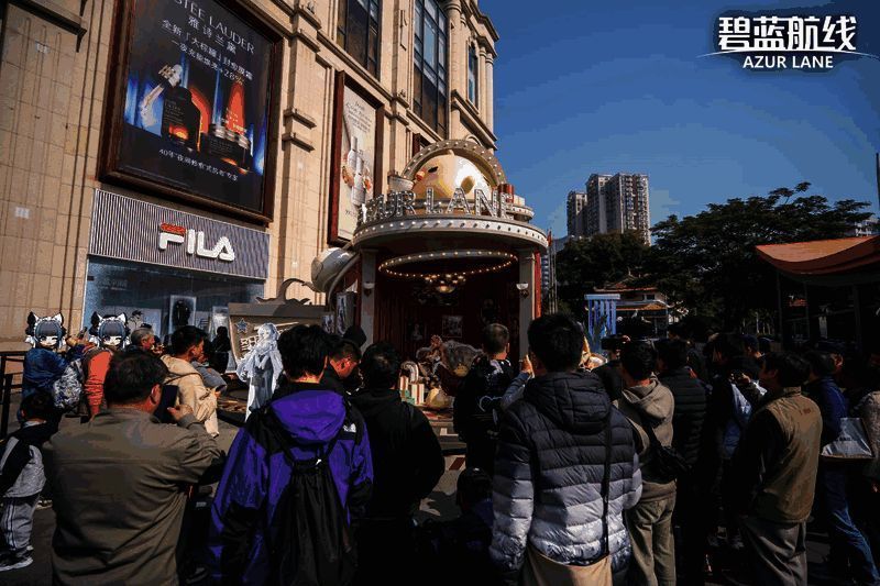 厦门站指挥官在圣诞树前合影留念，背景可见《碧蓝航线》角色立牌