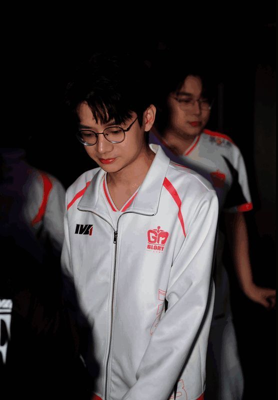 Gr_ac身着战队服装，手持麦克风面对镜头微笑