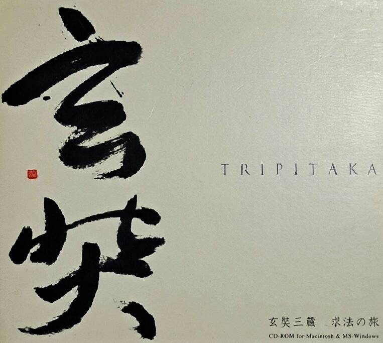泛黄的游戏光盘静静躺在木质托盘上，CD表面可见'TRIPITAKA'字样，背景是现代电脑设备与扫描仪