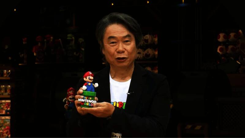 宫本茂接受采访现场照片，背景为任天堂经典游戏角色形象