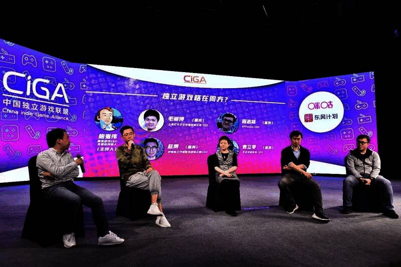 游戏展会上，观众围观试玩国产游戏，工作人员在一旁指导操作