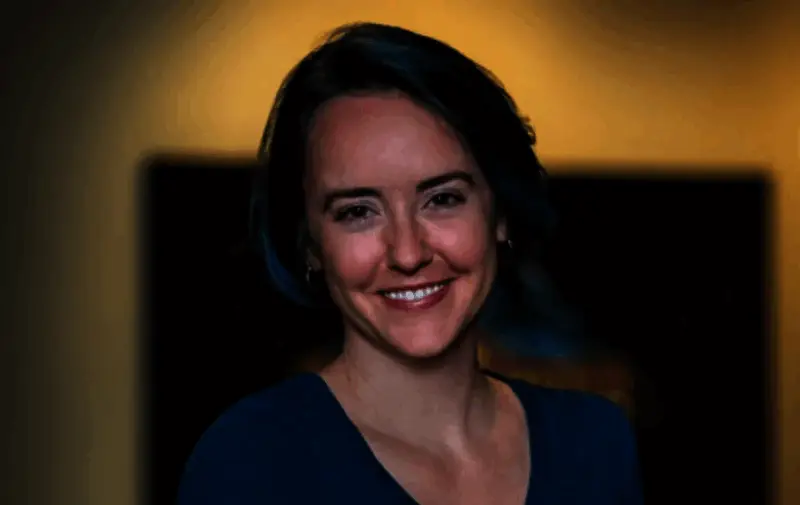 Carrie Patel在游戏开发者大会上的演讲现场，背景为《宣誓》游戏画面