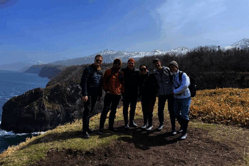 团队成员站在高处俯瞰北海道壮丽山景