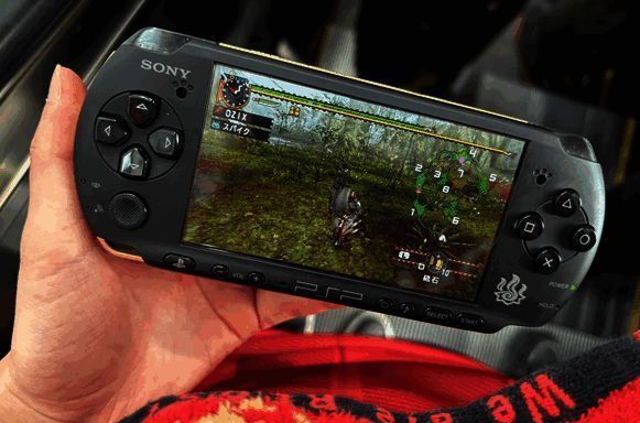 日本玩家在地铁上使用PSP游玩《怪物猎人》，周围路人投来好奇目光