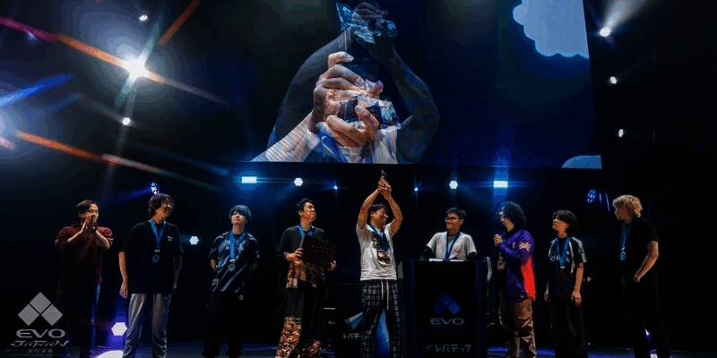 EVO日本2025现场画面，选手专注对战，大屏幕显示激烈战斗场景