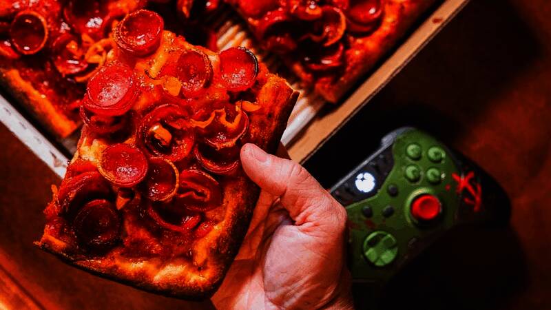 地狱火辣香肠披萨特写，表面覆盖浓郁芝士与红亮辣椒，散发炽热气息