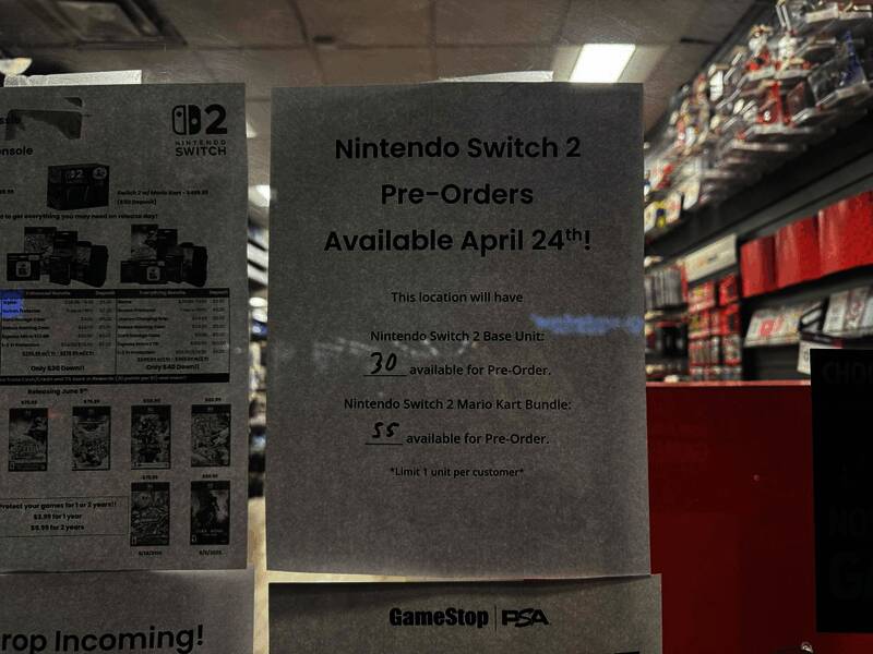 GameStop店内员工正在进行库存清点，货架上摆满Switch2主机包装盒