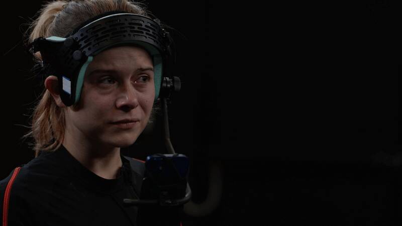 技术人员正在校准动捕设备，屏幕上显示角色模型同步动作