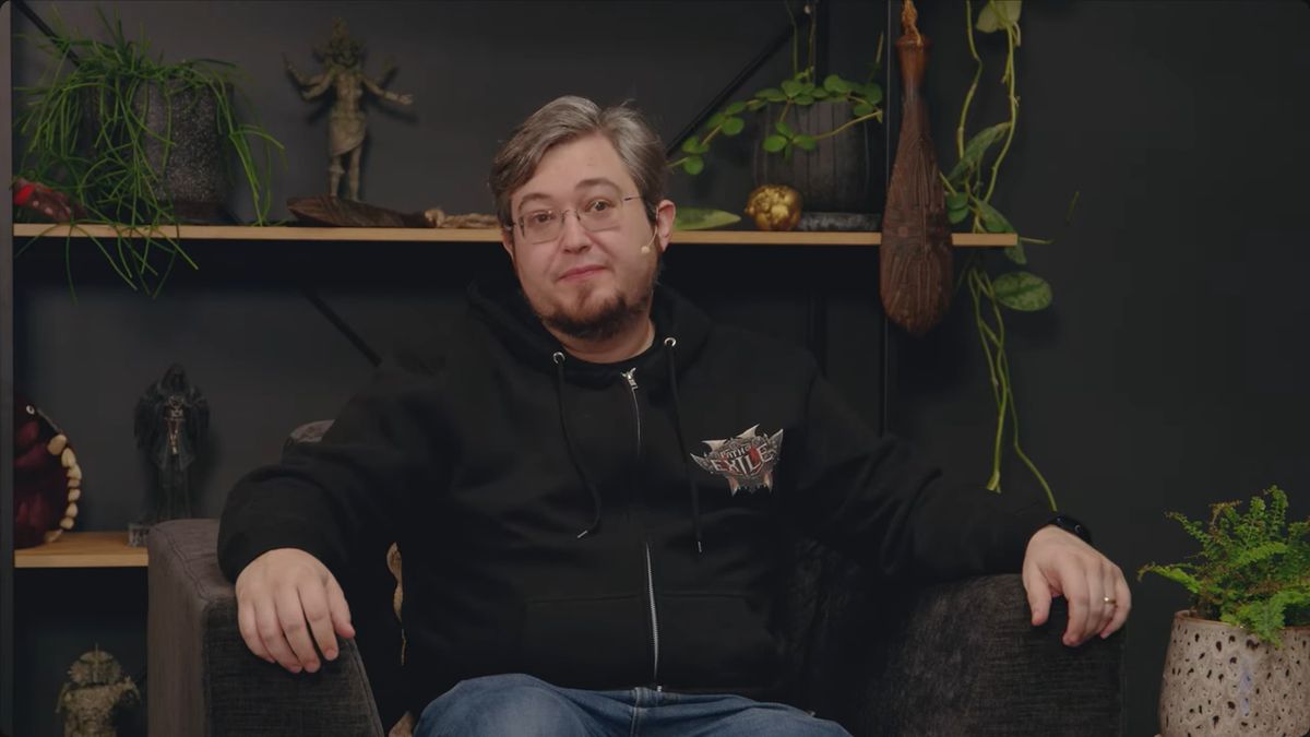 游戏总监Jonathan Rogers在视频中讲话画面，背景为服务器机房可视化数据图，显示实时连接用户数增长趋势