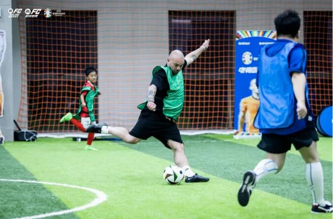 斯内德在活动现场签名合影，身旁有FC足球世界品牌展棚