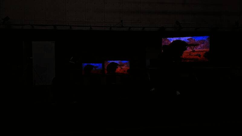 Capcom动作捕捉工作室全景，演员身穿动捕服在绿幕环境中进行表演，周围布满传感器和摄像设备