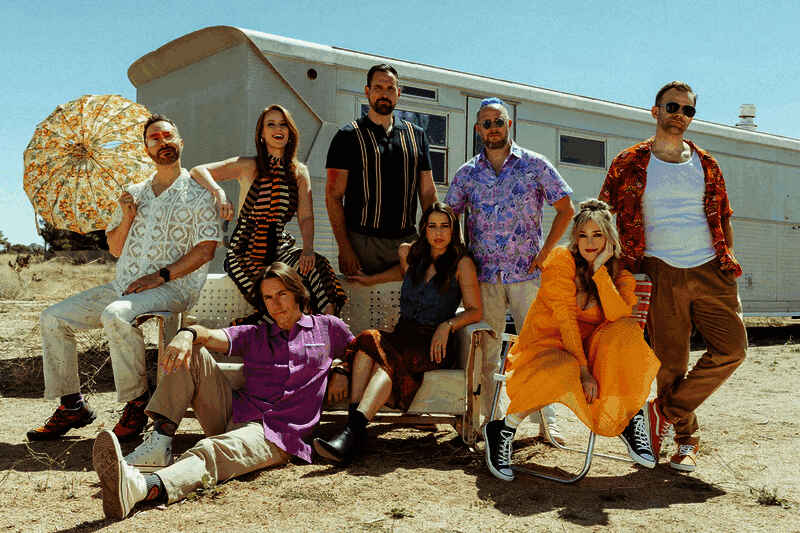 Critical Role团队围坐桌旁进行龙与地下城跑团实况，成员们神情投入，桌上布满骰子、地图与角色卡