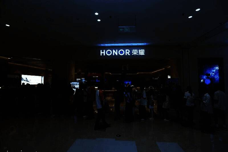 玩家在嘉年华现场与《永劫无间》Coser合影，背景为游戏主题展板，气氛活跃