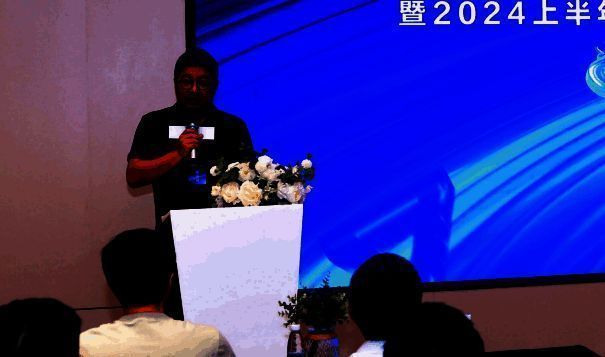 李长江在台上分享观点，神情专注