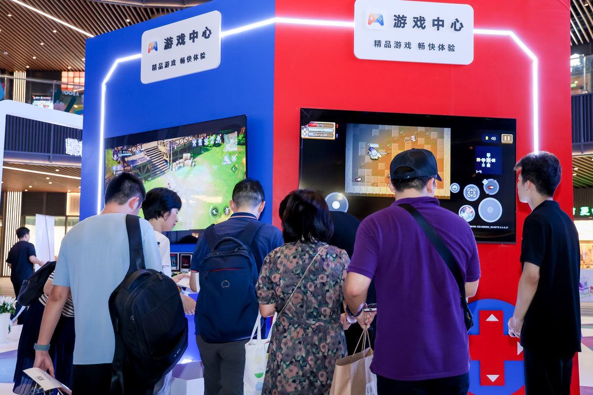 玩家正在使用NFC贴贴卡连接手机与游戏墙，屏幕上显示游戏下载界面