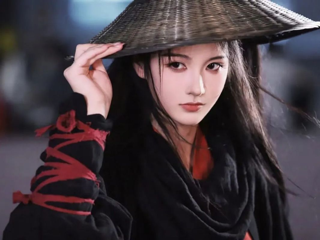 coser女刀客@纸鱼摆出游戏角色经典姿势，背景为红色灯笼装饰