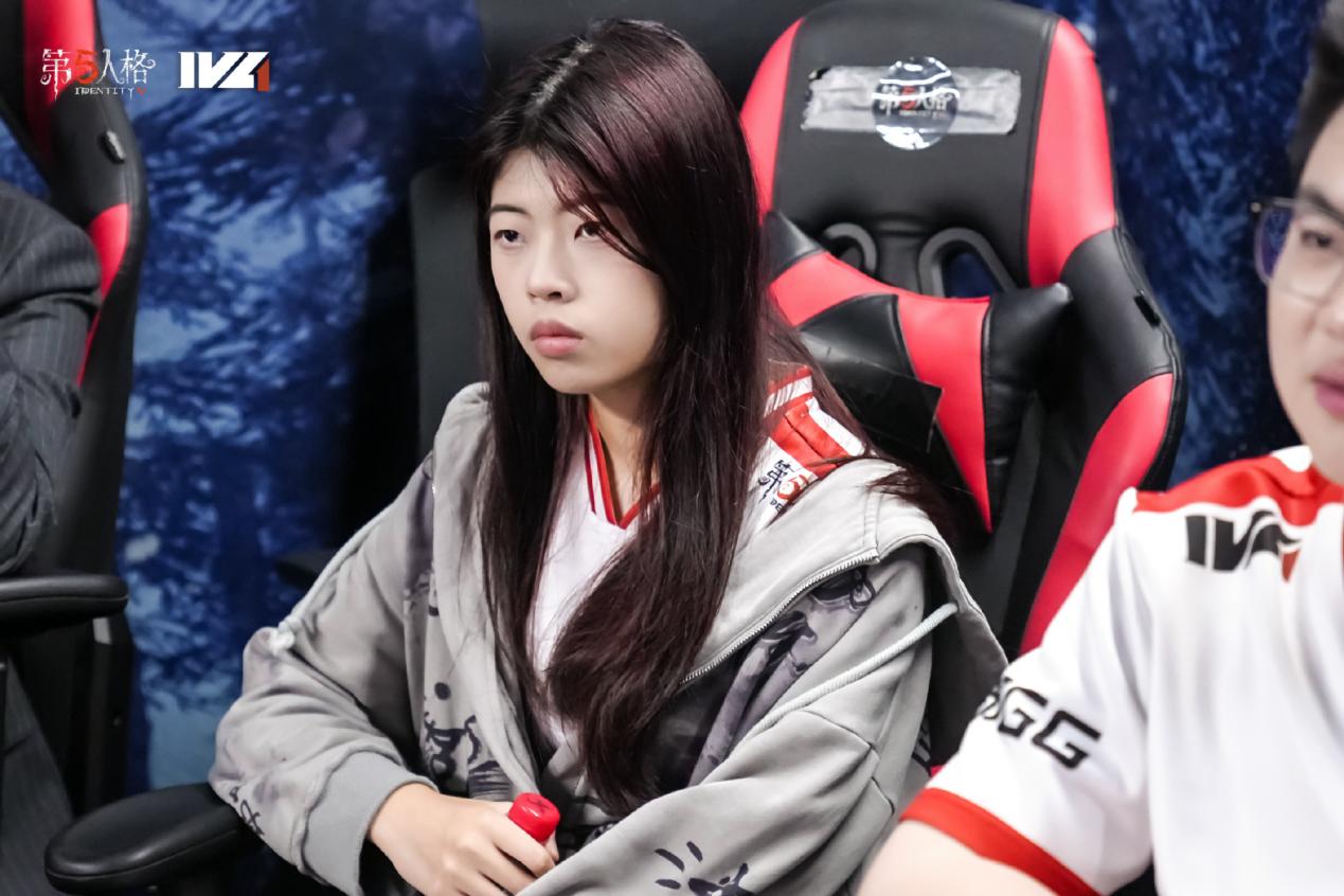 GG_violet选手正面特写，身穿成都GG队服，眼神坚定地望向前方，背景为战队LOGO与灯光舞台