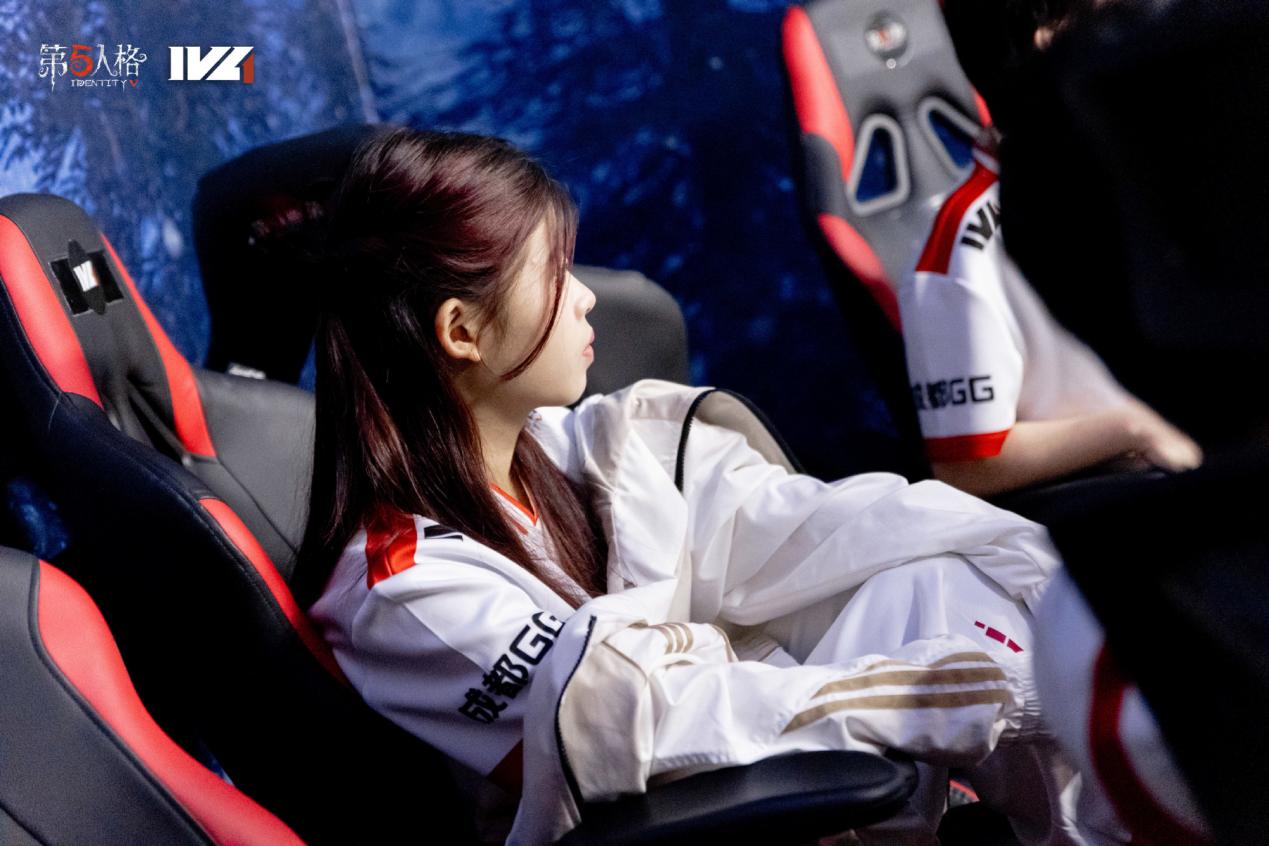 成都GG战队集体合影，GG_violet站在队伍中间，与其他队员笑容满面，背景为战队旗帜与灯光舞台