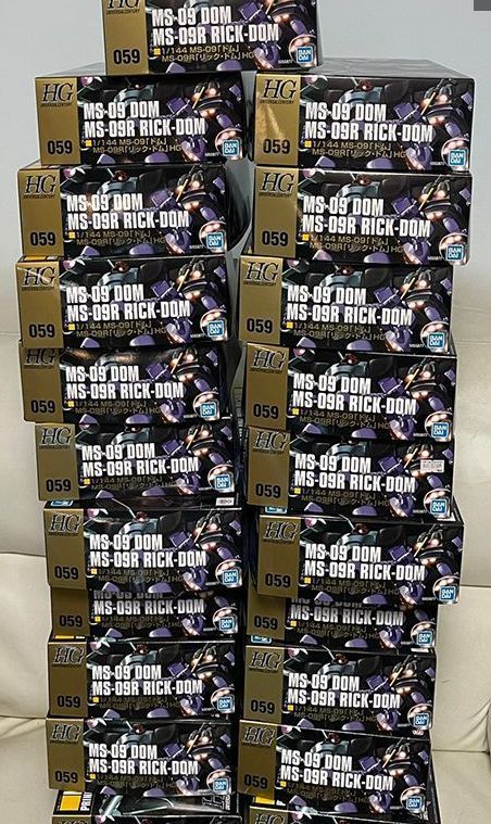 大量整齐堆放的里克·大魔钢普拉空盒，堆叠成小山状，背景为居家桌面环境