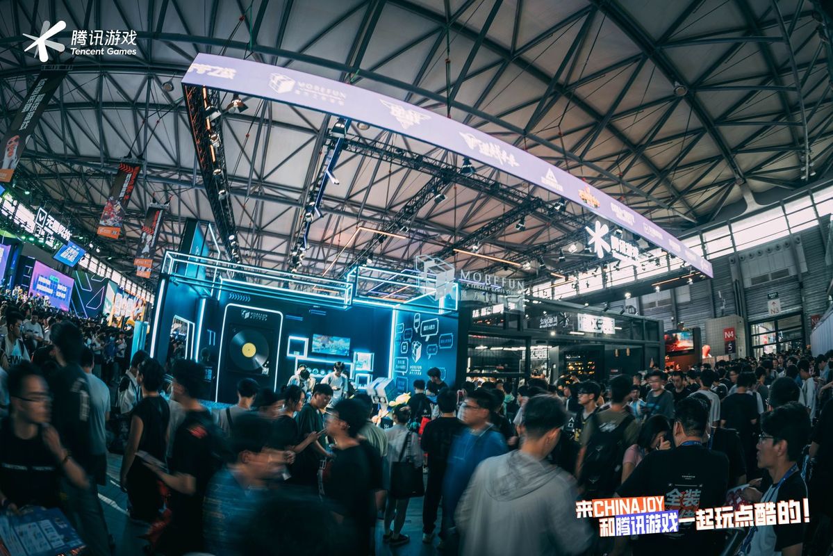 魔方工作室在ChinaJoy展会上的主舞台全景，现场人潮涌动，展台设计科技感十足，吸引大量玩家驻足