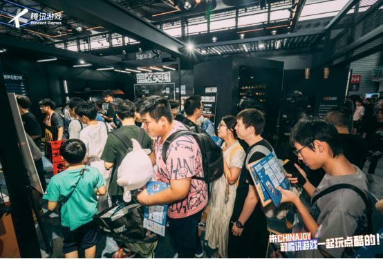 《暗区突围》展区内玩家体验射击项目，背景为游戏场景还原，氛围紧张刺激