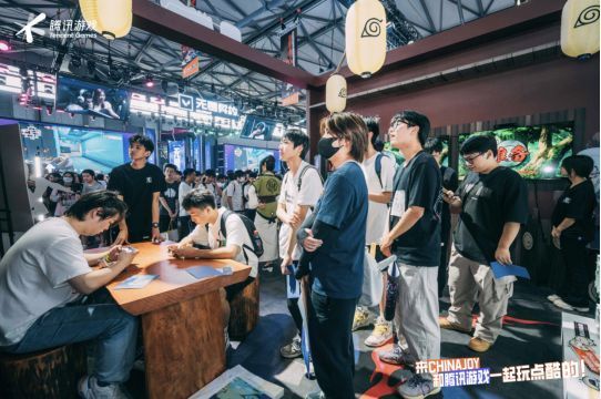 两名玩家在《火影忍者》展台进行1v1对战，周围观众围观，气氛热烈