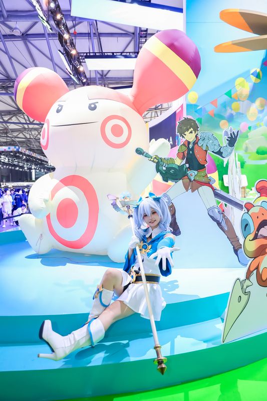 《云海之下》魔法师Coser在展台巡游，身穿蓝色长袍手持法杖，吸引玩家合影