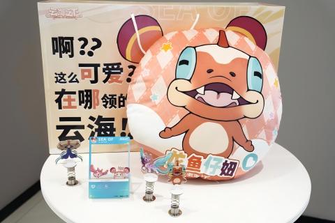 工作人员向玩家发放云海主题手提袋和Q版气球，背景展板展示游戏主视觉与幻兽角色
