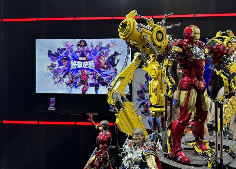 漫威85周年主题展台全景，展区内布满标志性英雄形象与红色主题装饰，现场人流如织