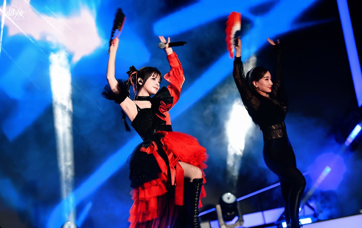 超级斩乐队在舞台上激情演出，灯光与特效交织，观众挥舞荧光棒