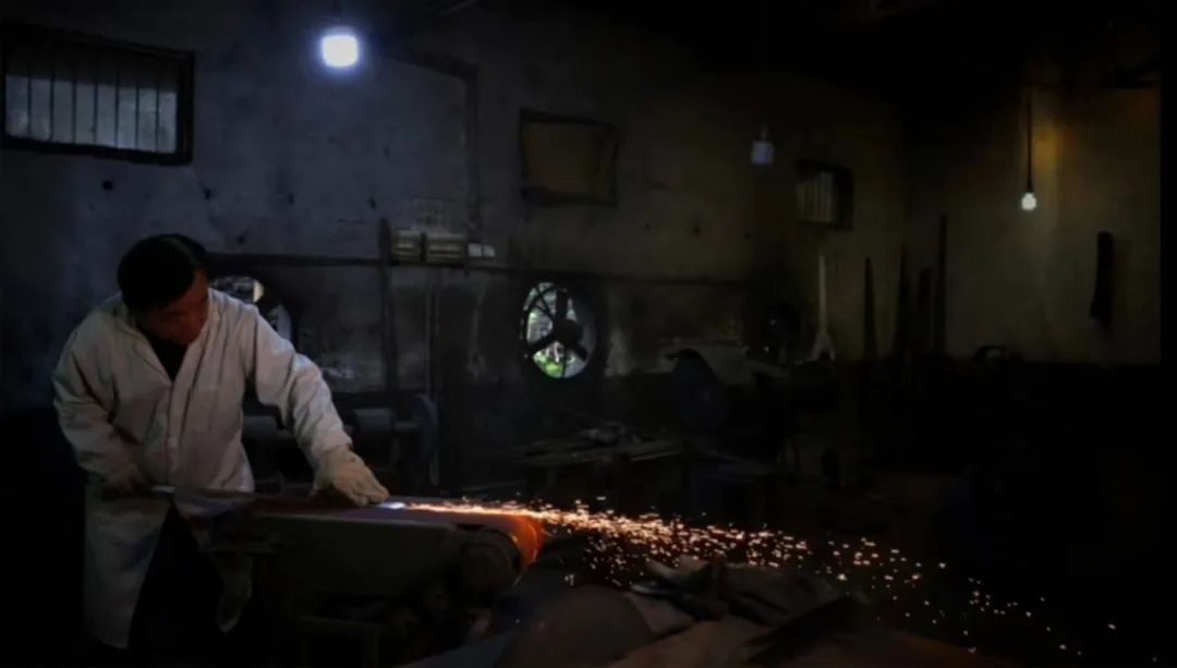 工匠正在锻打剑胚，火花四溅，展现棠溪宝剑传统手工锻造过程