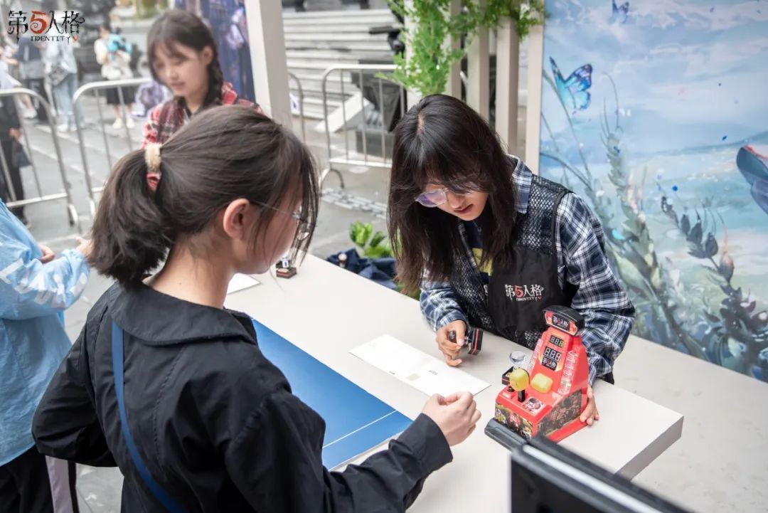 玩家在‘一锤定音’游戏中挥锤挑战，周围观众欢呼助阵