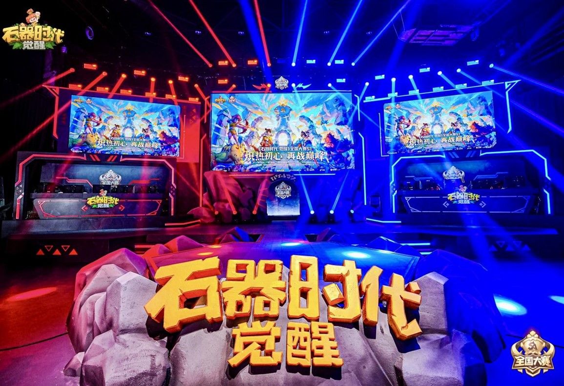 赛事现场全景图，舞台灯光璀璨，观众席座无虚席，氛围热烈