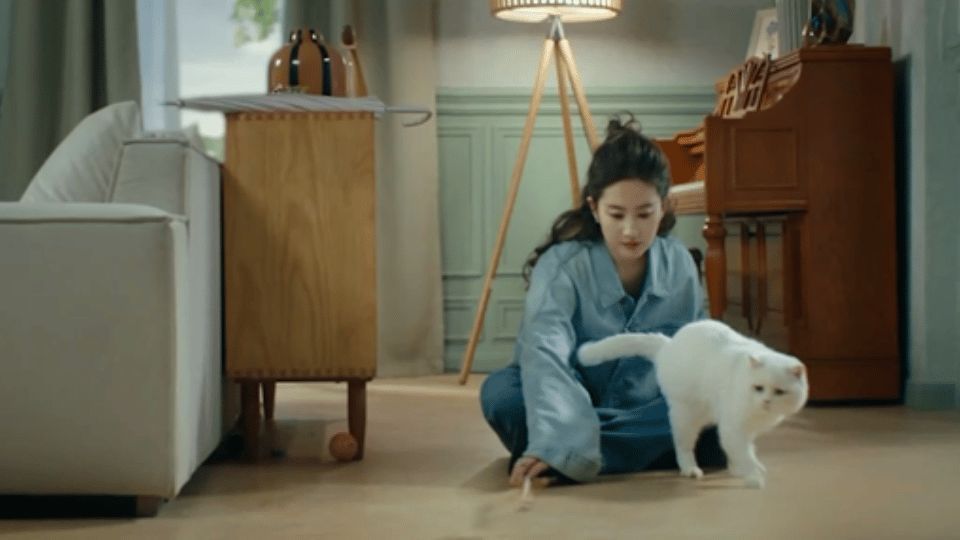 水蓝鼠Q版形象捧花站立，眼神呆萌，背景为粉色花海