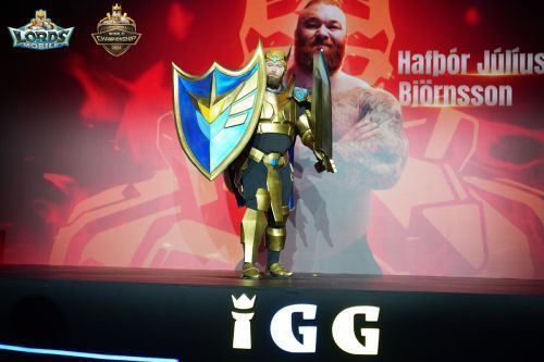 魔山骑士站在舞台中央，身穿铠甲造型服装，向观众挥手致意，背景大屏播放其影视形象