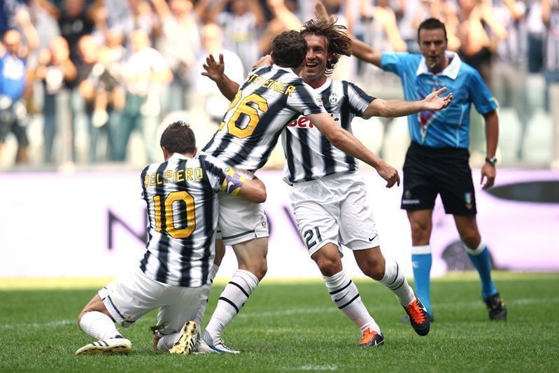 皮尔洛在比赛中从容控球，周围对手球员试图围抢但无法近身