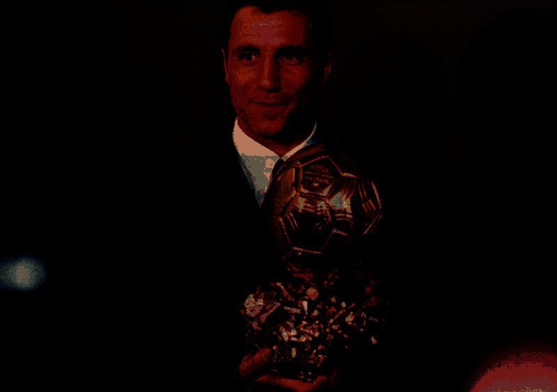 斯托伊奇科夫举起世界杯金靴奖杯的庆祝瞬间，脸上洋溢着自信笑容，背景为美国世界杯现场