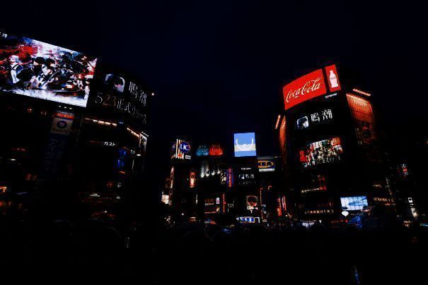 东京街头的《鸣潮》巨型广告牌，夜晚灯光璀璨，角色形象清晰醒目