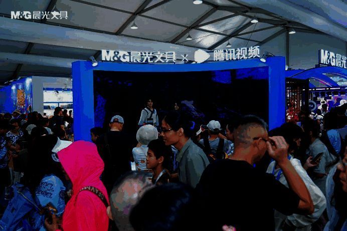 展台内设置多个国漫主题拍照区，粉丝手持联名文具与背景墙合影留念