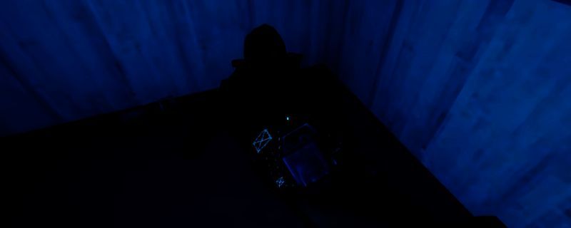 《非生物因素》游戏中教团狙击手潜伏在高台上的画面，身穿灰色长袍，手持狙击枪，隐藏在废墟之中