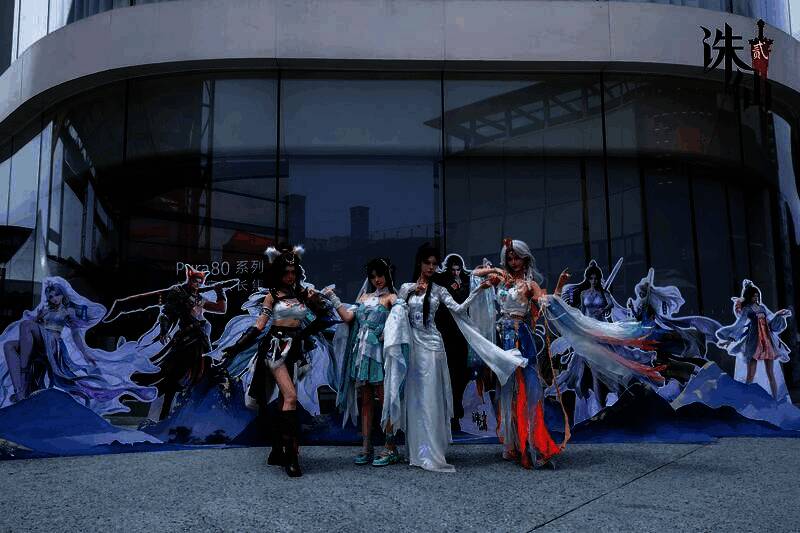 活动闭幕合影，玩家与工作人员在《诛仙2》主题背景前庆祝活动成功，现场气氛热烈