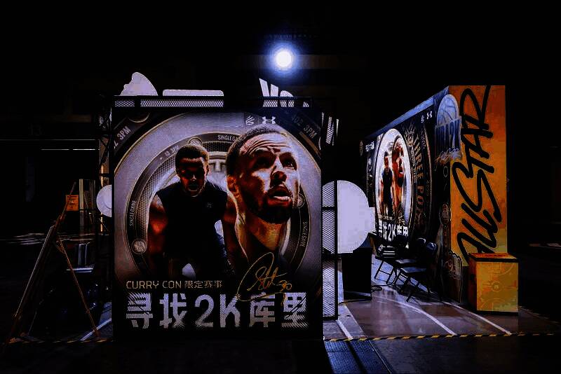 NBA2K手游展区全景，玩家排队等待试玩游戏，展台灯光炫酷，充满科技感