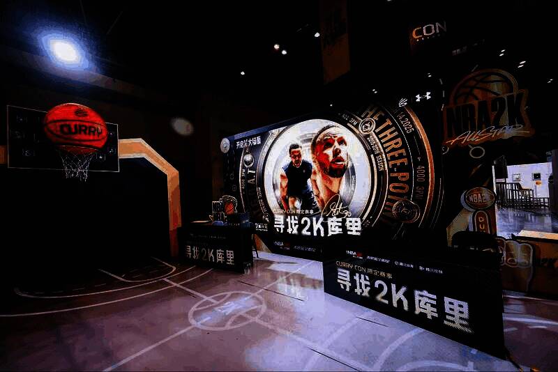 玩家正在试玩NBA2K手游，神情专注，周围有工作人员指导操作
