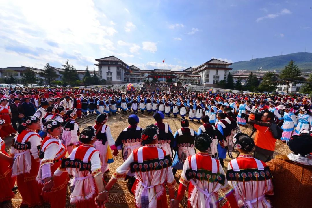 三多节庆典现场，纳西族群众身着传统服饰载歌载舞，气氛热烈，展现民族节日的欢乐氛围