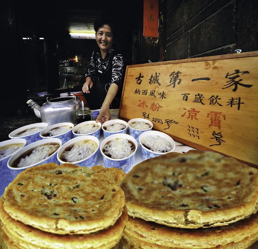 丽江特色美食拼盘，包含金黄酥脆的丽江粑粑和晶莹剔透的鸡豆凉粉，摆盘精致，令人垂涎