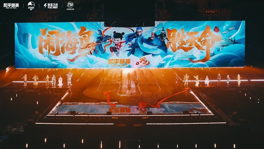 唐汉霄身穿红色机甲风战衣，手持长枪立于火焰特效之中，背后是哪吒巨像投影